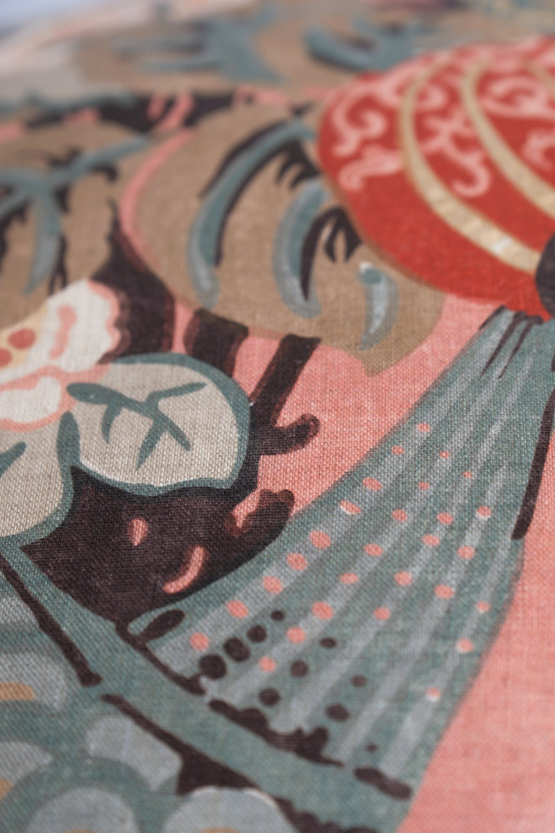 Close up of a floral linen with a large boquet of flowers in salmon, red, duck egg blue and rich brown.