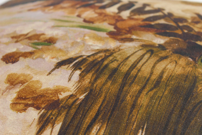 Close up of a fabric featuring an impressionist style painting of a forest scene in natural colours
