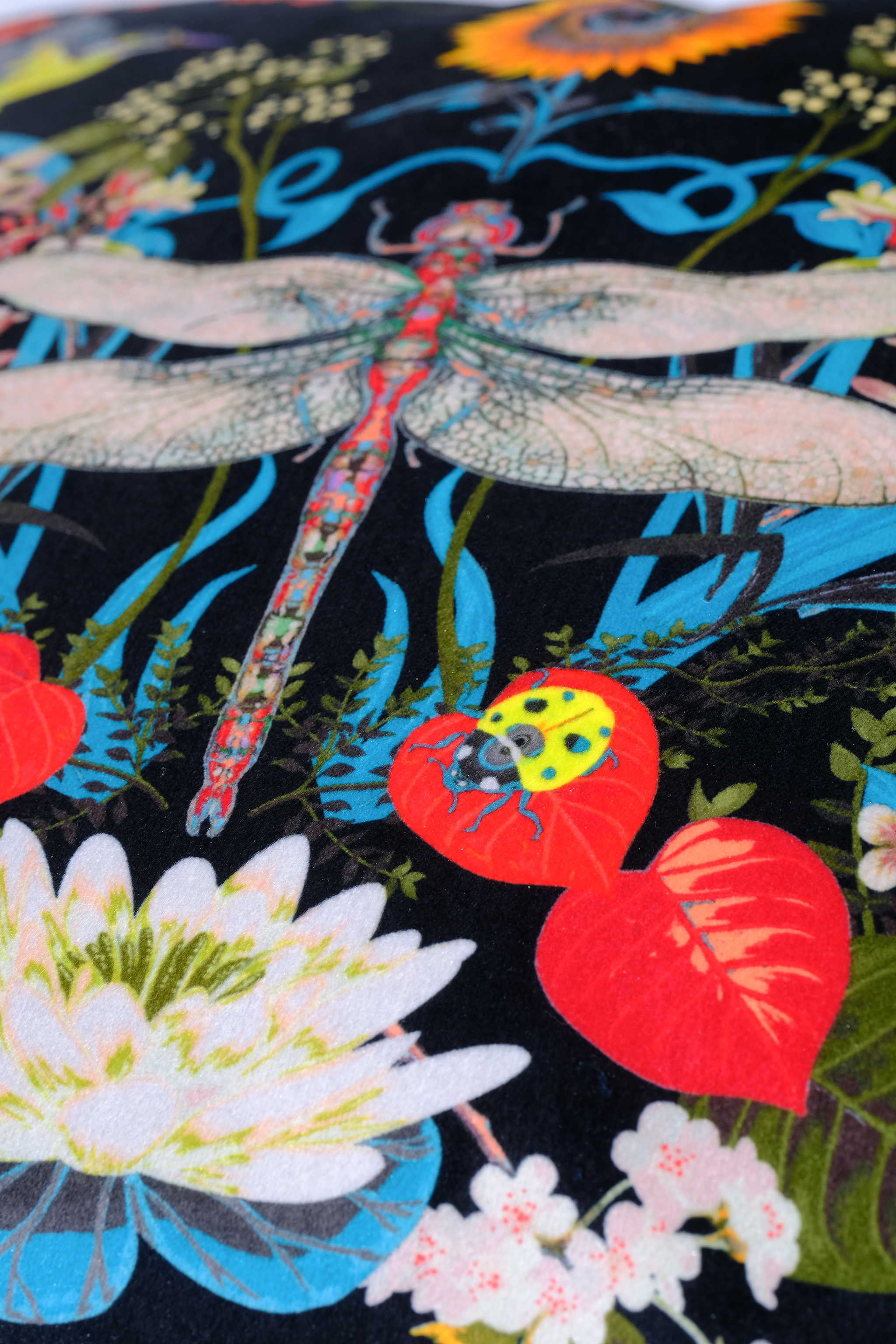 Colorful fabric with dragonflies and flowers on a black background