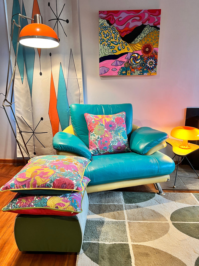 photo of a retro themed living room with flower cushions displayed on a turquoise vinyl chair.