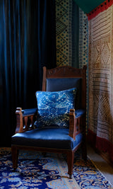 Rich moody room setting with a indigo damask cushion sitting on a vintage chair