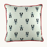Photo of a cushion with small inky navy lobsters printed onto a white linen with a bright red velvet piping