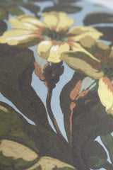 Close-up of a floral pattern with yellow flowers and green leaves on a light blue background
