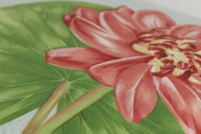 Close-up of a fabric showing a pink flower with green leaves on a light blue background