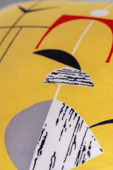 Close up of a vintage fabric with geometric shapes on a bright yellow base.