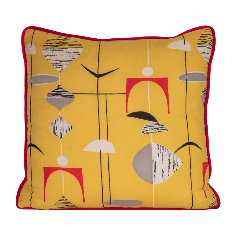 Colourful cushion made from a vintage fabric with geometric shapes on a bright yellow base.