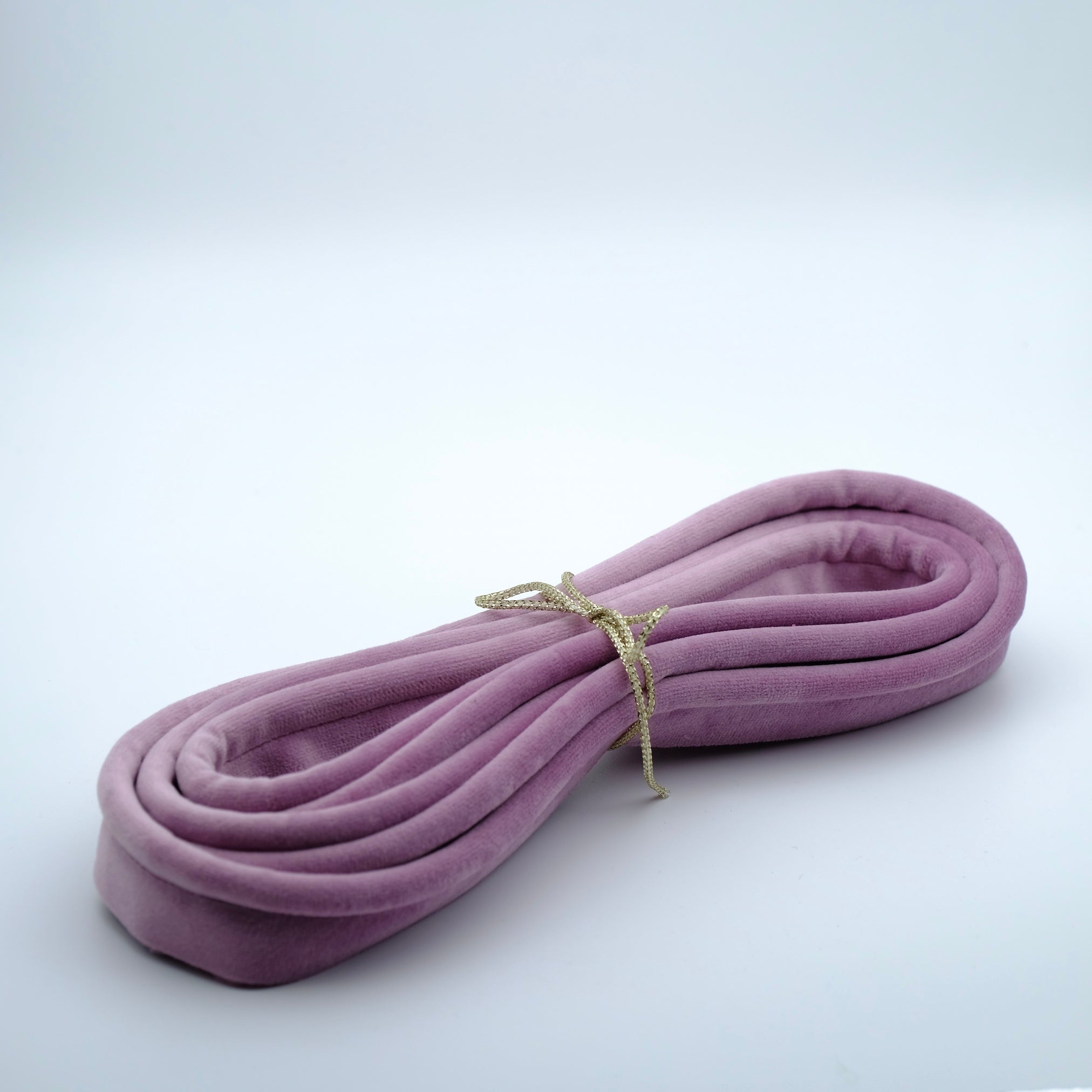 Image of a bundle of lilac / mauve coloured velvet piping.