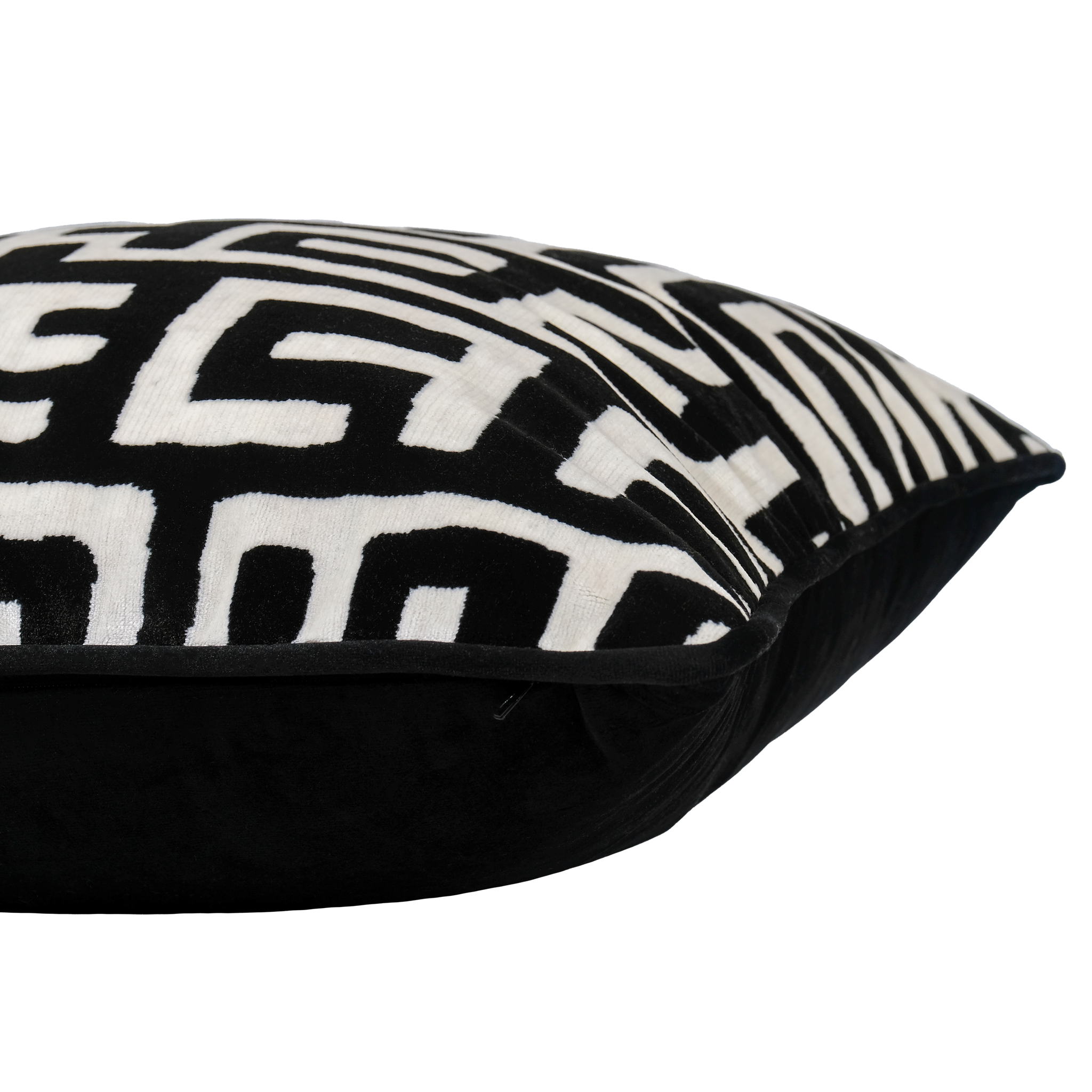 Side photo of a black and white labyrinth patterned velvet cushion