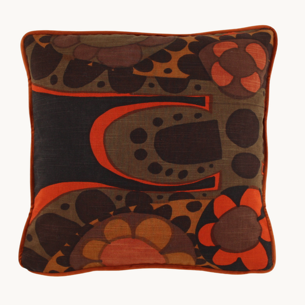 Photo of a cushion made from vintage fabric from the 1970s - a large scale design in a classic 70s palette of orange and brown