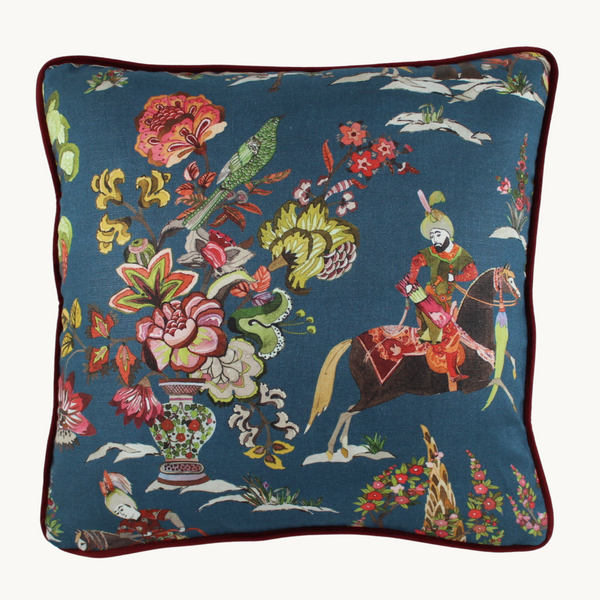 Photo of a linen cushion with a printed design featuring Ottoman Riders and flowers on a blue background