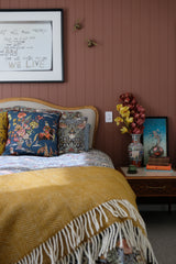 photo of a relaxing bedroom with a pictorial blue linen cushion featured