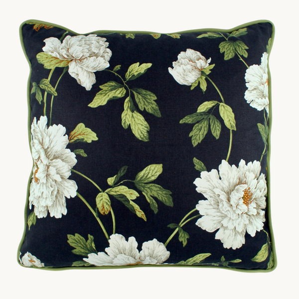 Photo of a cushion with a black background and white peony flowers with green foliage