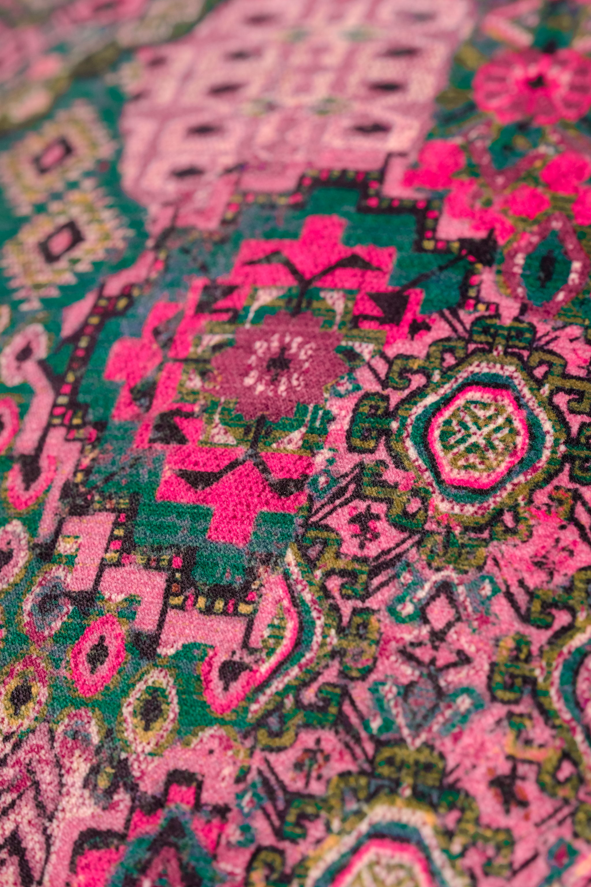 Close-up of a vibrant, patterned fabric with pink and green colors.