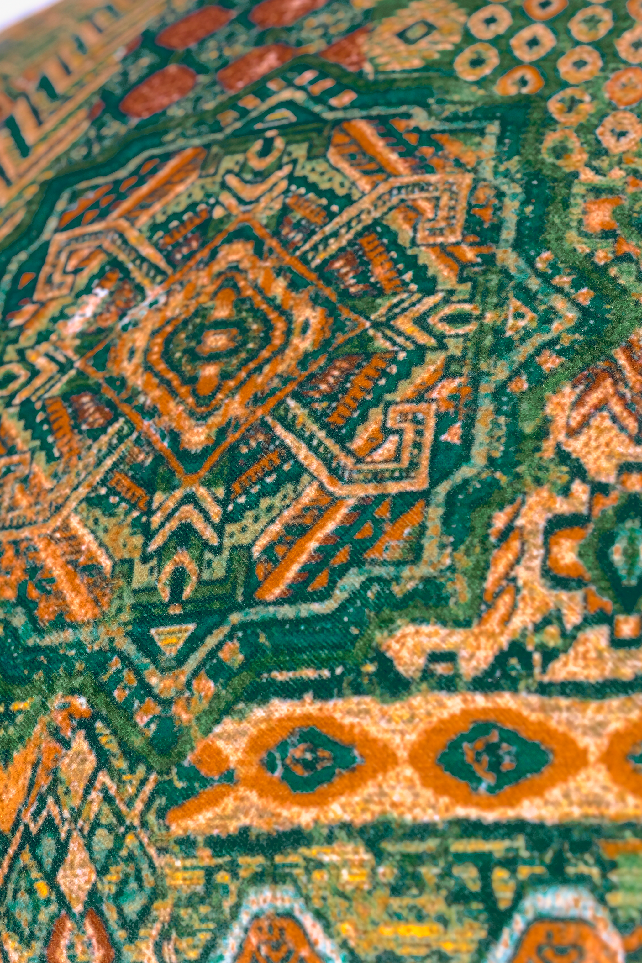Close-up of a Persian patterned fabric with green, and brown colors.