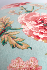 Close up of a linen with a pale blue background and pink and red poppies