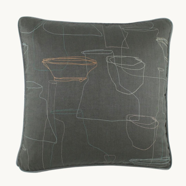 Photo of a very muted cushion with a grey linen basecloth and outlines of finely drawn mid century ceramics.