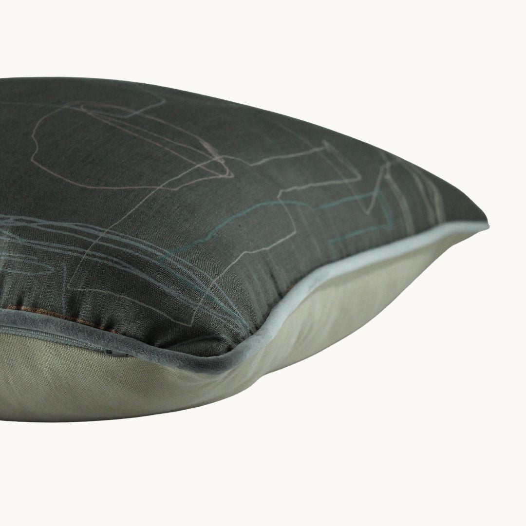 Side photo of a very muted cushion with a grey linen basecloth and outlines of finely drawn mid century ceramics.