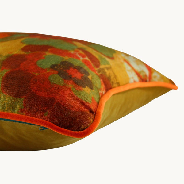 Side photo of a cushion made from a vintage linen with a distinct 1970s feel - bright orange, green, chocolate and gold stylised flowers.