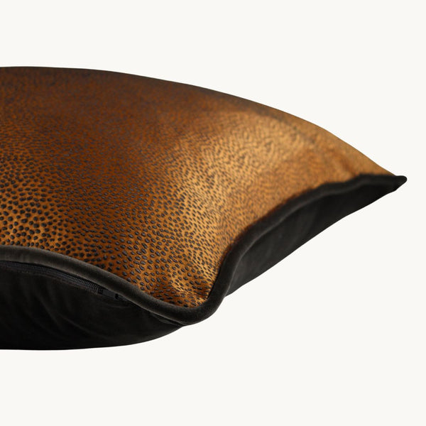 Side shot of a rich earthy tobacco coloured cushion with a diffuse textured spot