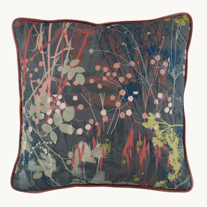 Photo of a botanical cushion in dusty colours with silhouettes of grasses, seed heads and foliage