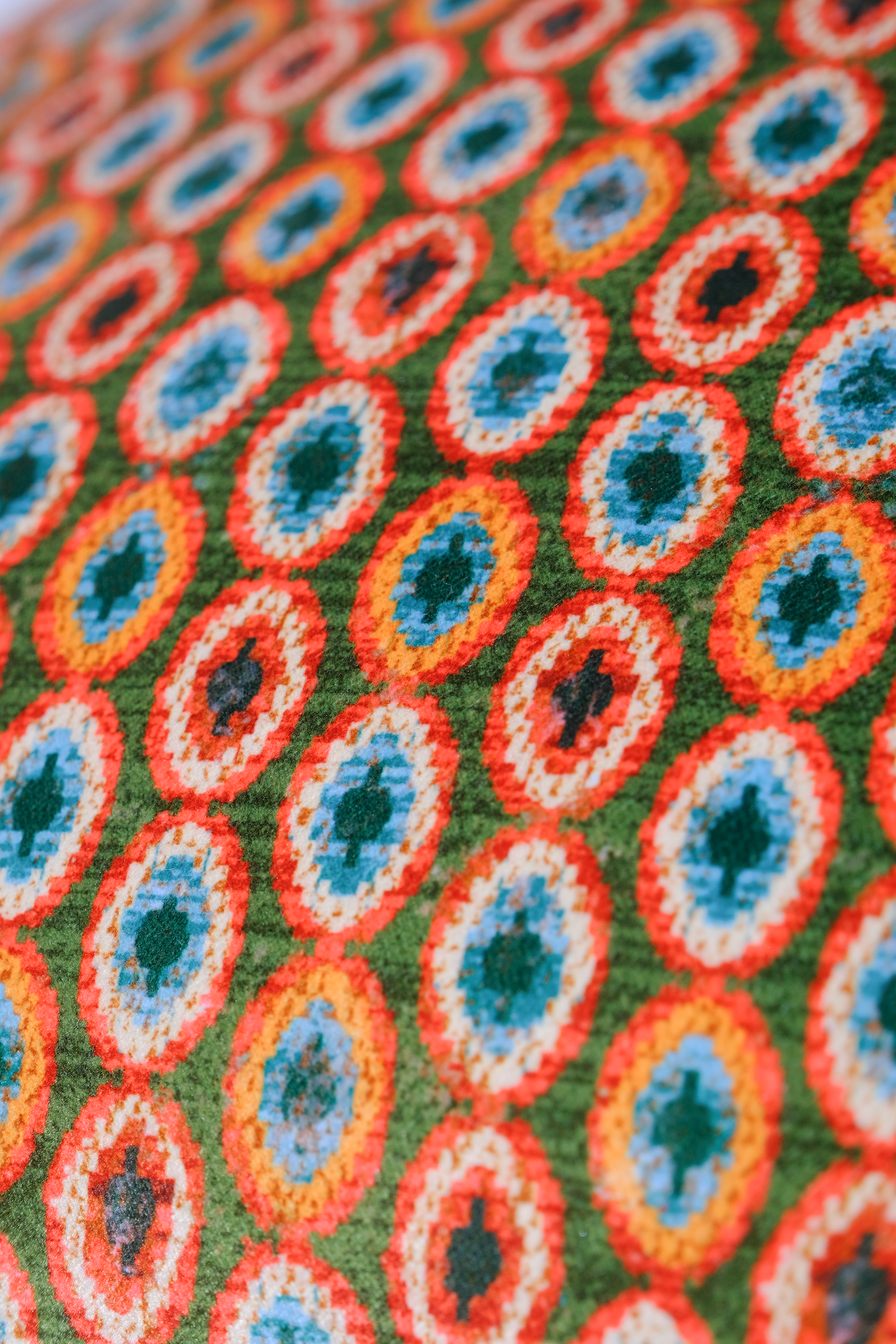 Close-up of a fabric with circular pattern in red, blue, and green.