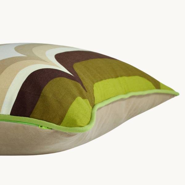 Sides shot of a cushion with an graphic 1970s design in shades of green and neutrals