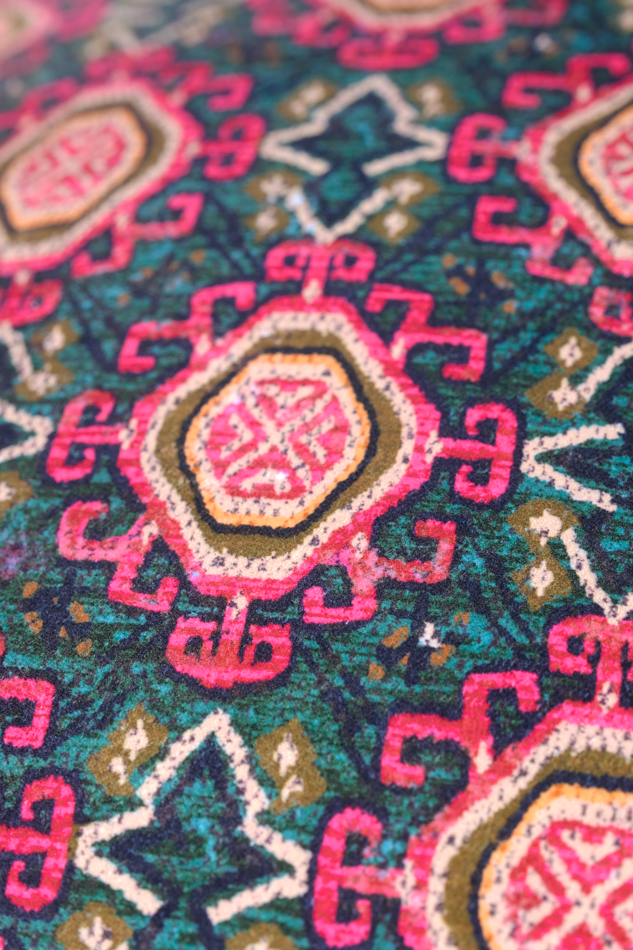 Close up of a persian patterned velvet in pink and teal