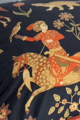 Close-up of fabric with a persian rider on horseback and floral design.