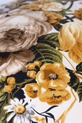 Close-up of a floral pattern with yellow flowers and green leaves on a white background.