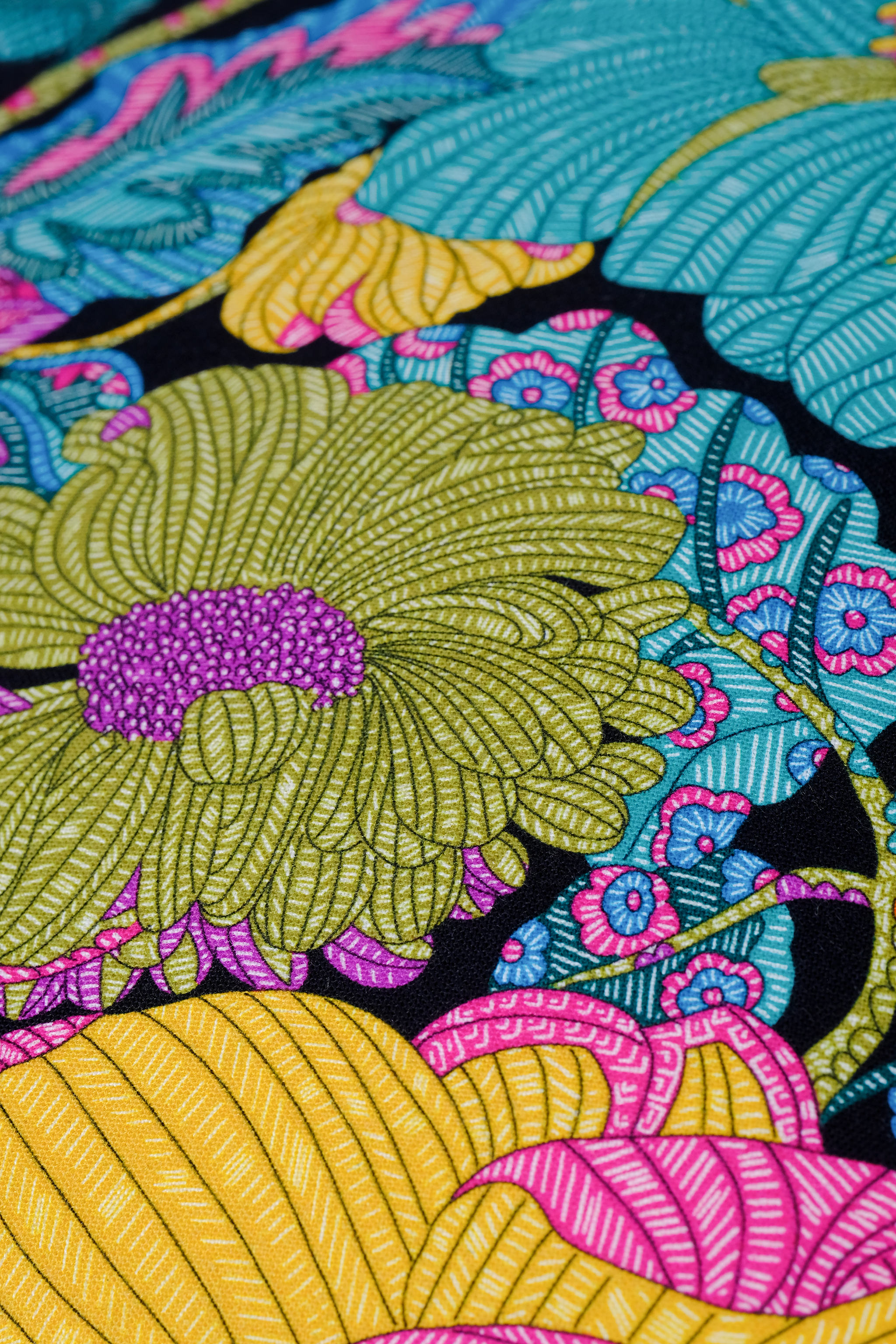 Colorful floral pattern with green, yellow, pink, and blue on a black background