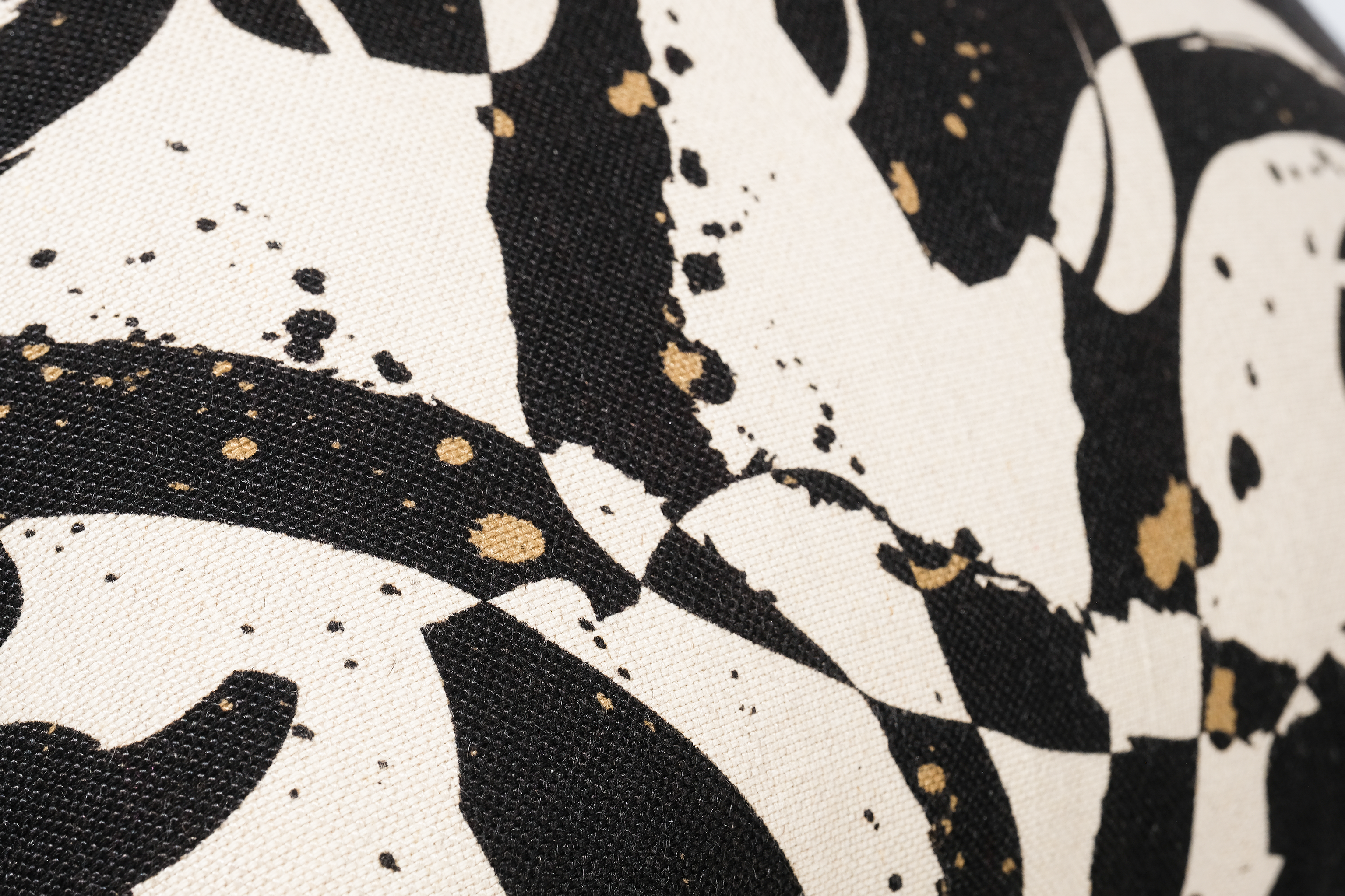 Close-up of a patterned fabric with black, white, and gold design.