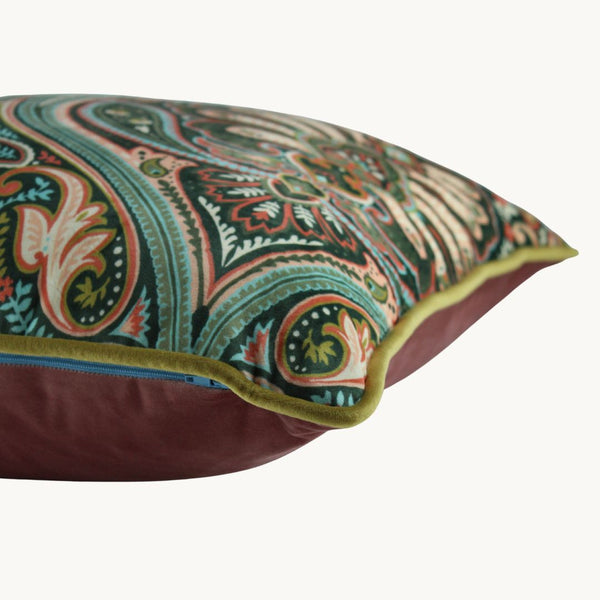 Side photo of a velvet cushion with a design inspired by motifs from the Ottoman Empire in muted greens and pinks