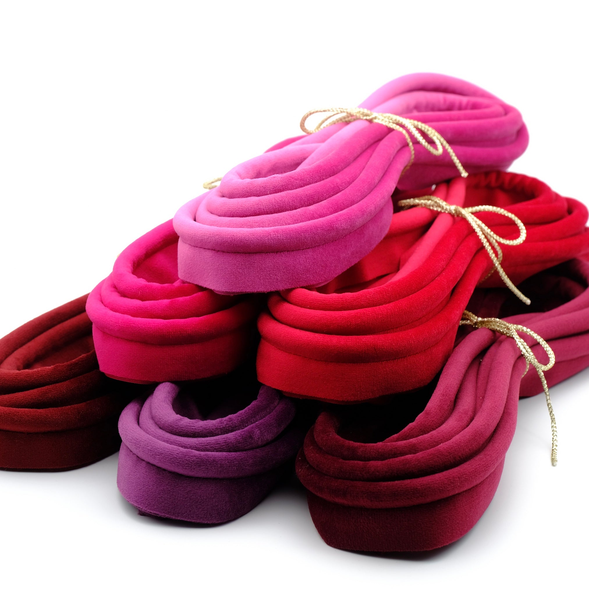 A stack of warm coloured velvet piping bundles