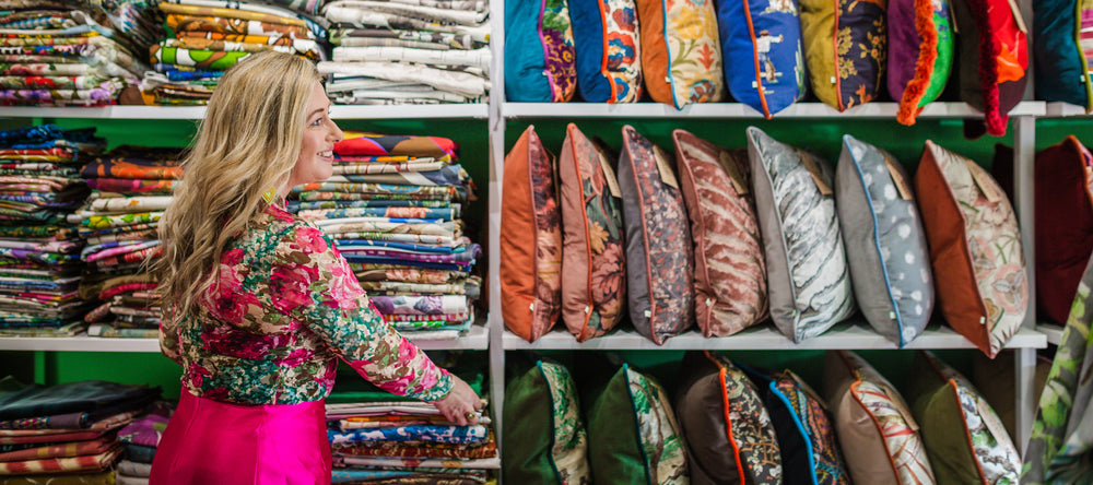 Woman looking at colorful fabrics and pillows in a store