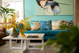 Photo of a living room with aqua coloured walls, a turquoise sofa and lots of cushion