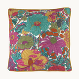 Photo of a bright colourful floral cushion with retro inspired flowers in hot pink, grape, bright turquoise, coral and orange.