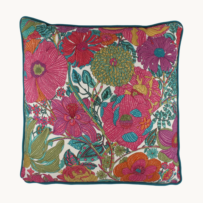 Photo of a bright colourful floral cushion with retro inspired flowers in hot pink, grape, bright turquoise, coral and orange.