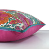 Side view of a bright colourful floral cushion with retro inspired flowers in hot pink, grape, bright turquoise, coral and orange with turquoise piping and a fuschia cotton back