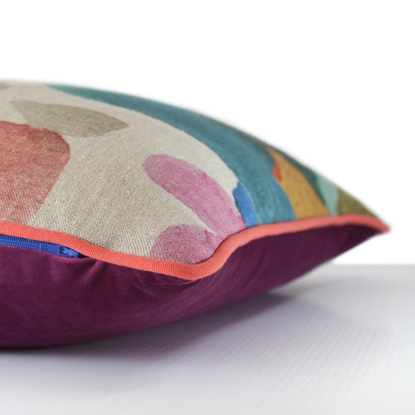 Side view of a colourful abstract cushion with royal purple, turquoise, pink and forest green painterly large scale splotches