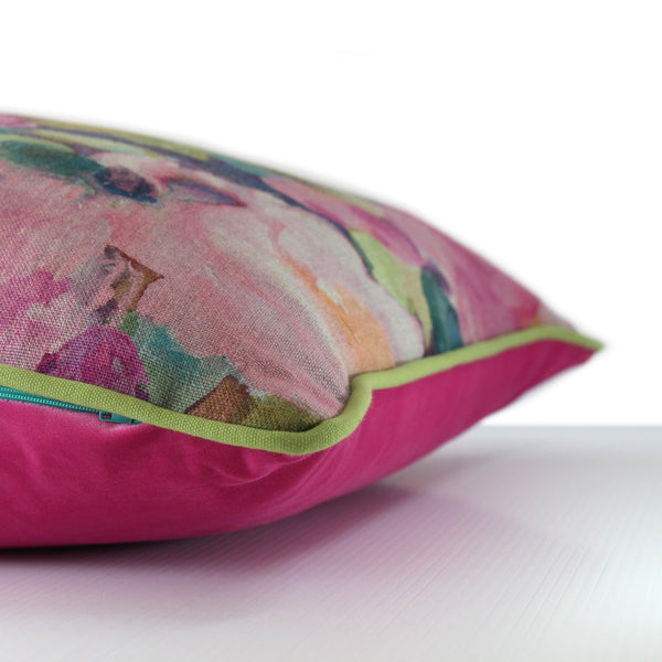 Side view of a painterly floral linen cushion in pinks and greens