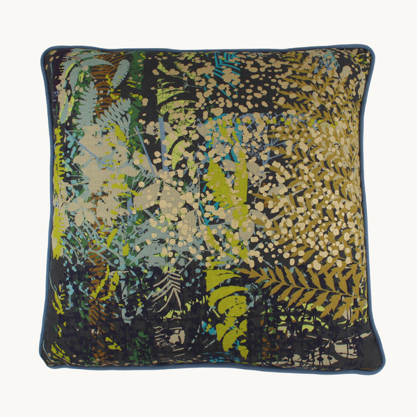 Photo of a kaleidoscopic botanical cushion with overlapping layers of leaves and seedheads in dark grey, lime, powder blue, bright turquoise, aubergine, rust and metallic gold