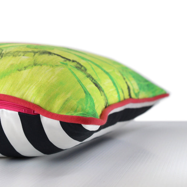 Side view of a linen cushion in a painterly design with bright yellow, white, lime green, hot pink and black