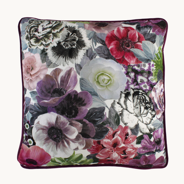 Photo of a vibrant floral cushion with a combination of painterly and digital blooms in purple, raspberry, lime, black and white.