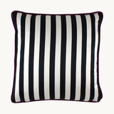 Crisp black and white striped back of a vibrant floral cushion with a combination of painterly and digital blooms in purple, raspberry, lime, black and white.
