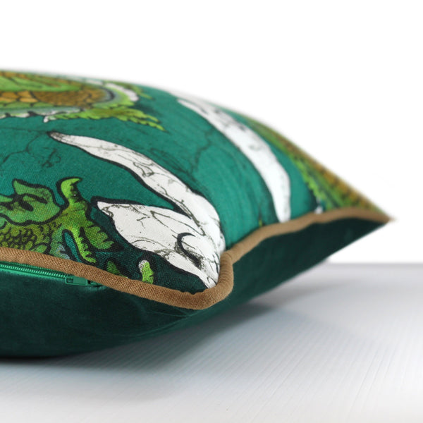 Side view of a cushion with emerald green stylised dragons and clouds, khaki piping and emerald velvet back
