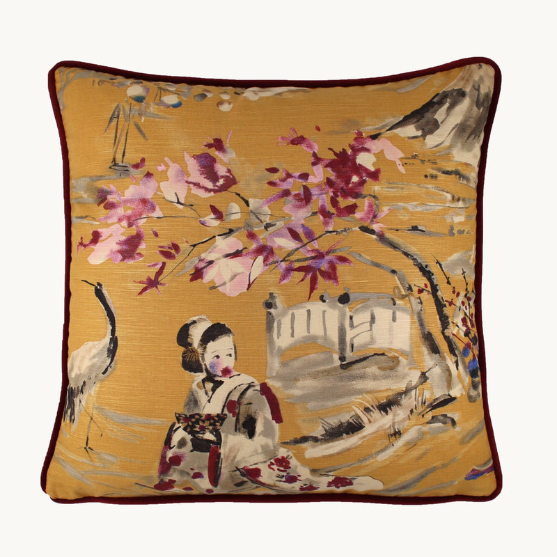 Photo of a cushion with a gold background and a painterly Japanese scene of a geisha and cherry blossoms