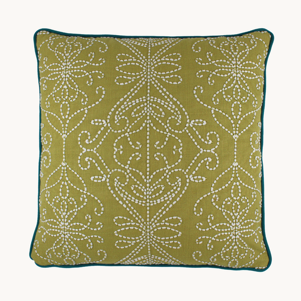 Photo of a chartreuse coloured cushion with white chunky scrolled embroidery detail