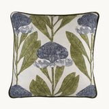 Photo of a cushion with a crisp white background and linear powdery blue proteas with green leaves