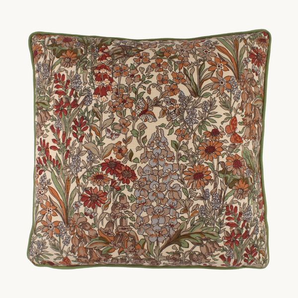 Photo of a cushion in a small scale Liberty floral in taupes, persimmon and brick colours