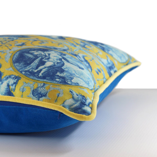 Side view of a vibrant yellow and cobalt blue cushion with ancient greek inspired imagery, bright yellow velvet piping and a cerulean blue velvet back